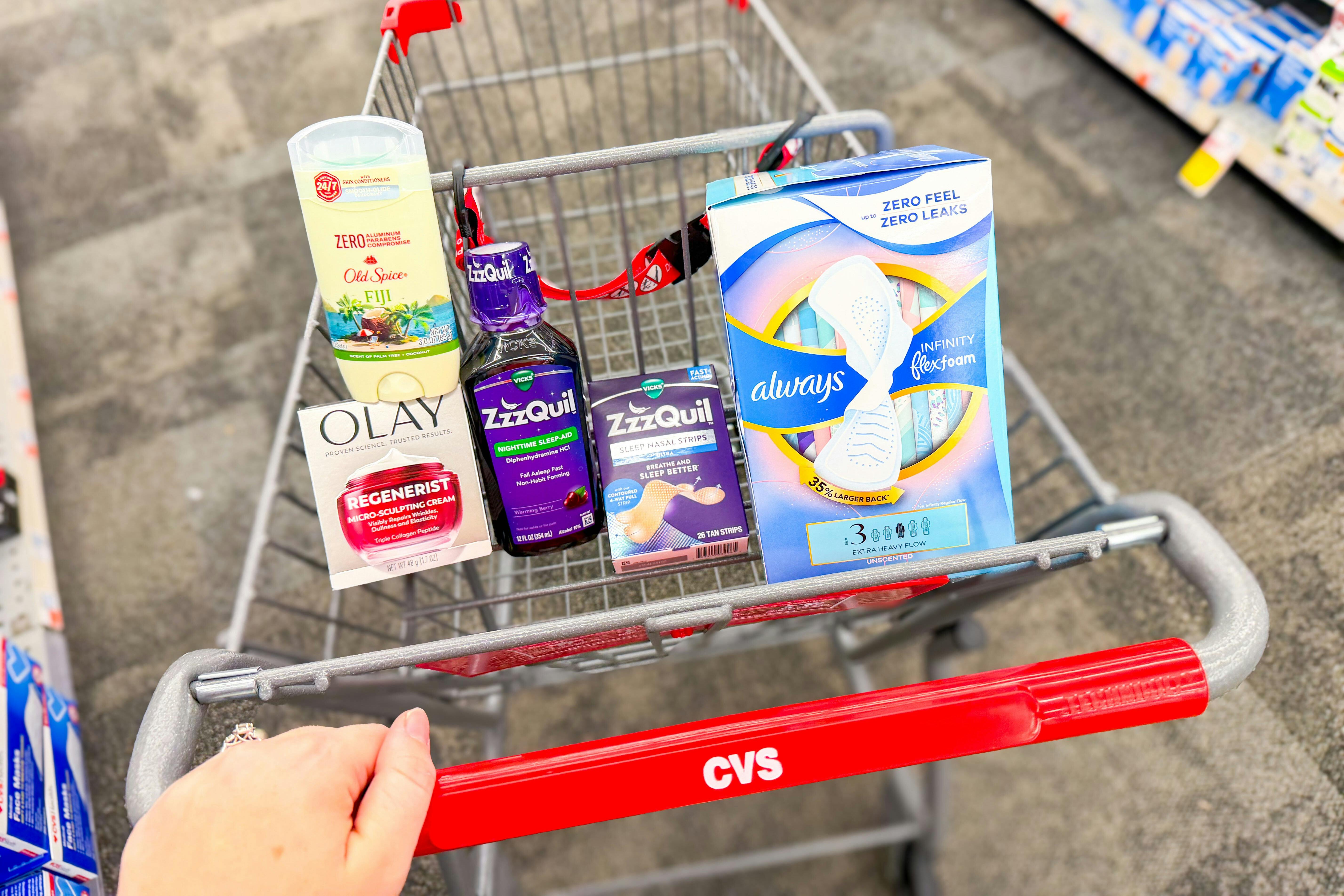 person pushing a cart with old spice deodorant, olay moisturizer, zzzquil products, and always pads