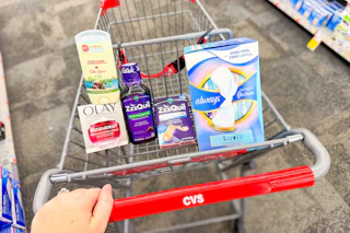 person pushing a cart with old spice deodorant, olay moisturizer, zzzquil products, and always pads