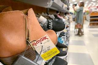 A pair of brown ankle boots with a yellow clearance tag on them.