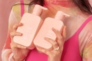 a woman holding shampoo and conditioner