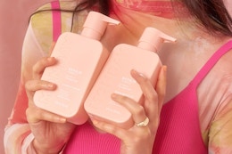 a woman holding shampoo and conditioner