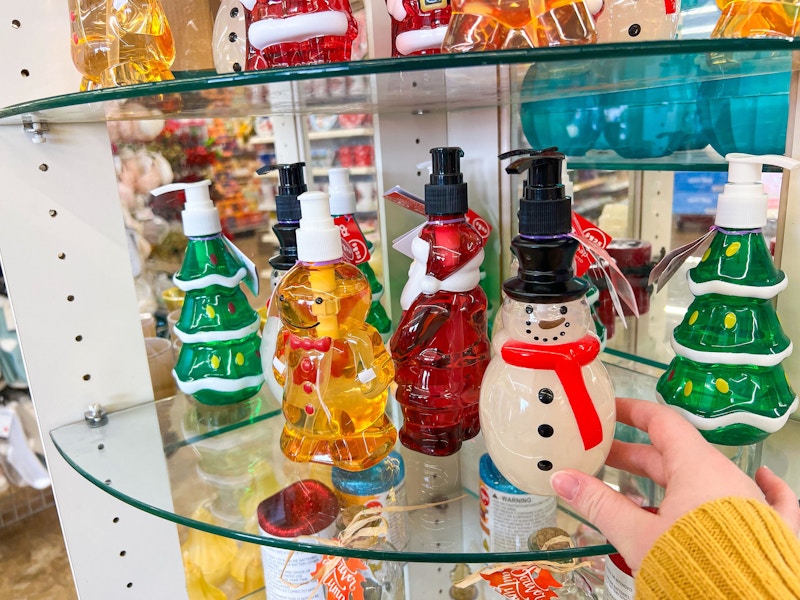 person grabbing a snowman hand soap off a shelf