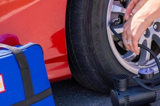 a woman pumping her car tire