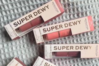 pink and peach blush tubes in packaging on a grey cloth