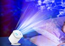 a galaxy projector on a nightsta