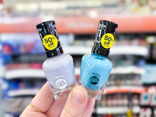 hand holding two nail polishes