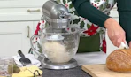 a person using a silver kitchen mixer on a counter