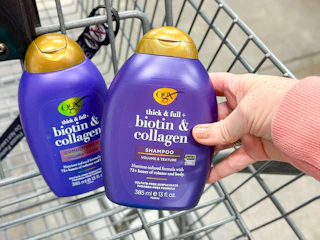 hand holding a bottle of ogx shampoo