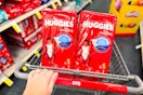 person pushing a cart with huggies diapers in it