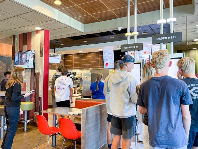 a groups of people in line inside mcdonalds