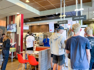 a groups of people in line inside mcdonalds