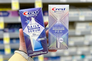 hand holding boxes of crest teeth whitening pen and serum