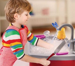 A boy playing with a Play22 kitchen sink.