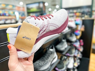 hand holding up asics shoes