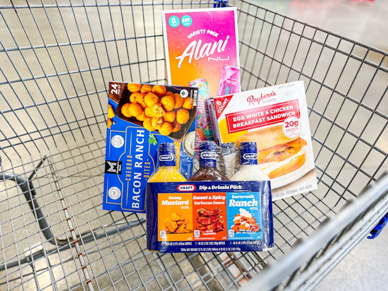 grocery items in a cart including energy drinks, dipping sauce, breakfast sandwiches, and cheddar bites