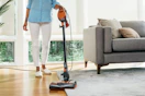 a woman using a shark vacuum 