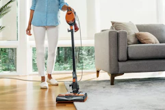 a woman using a shark vacuum 