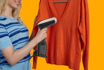 a person using a garment steamer on a sweater