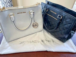 michael kors handbags on table