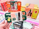 Someone holding a Benefit Merry Mini Mail Ulta gift set in front of a shelf at Target
