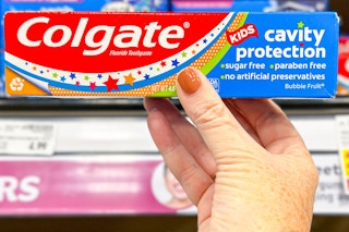 hand holding a tube of colgate kids toothpaste
