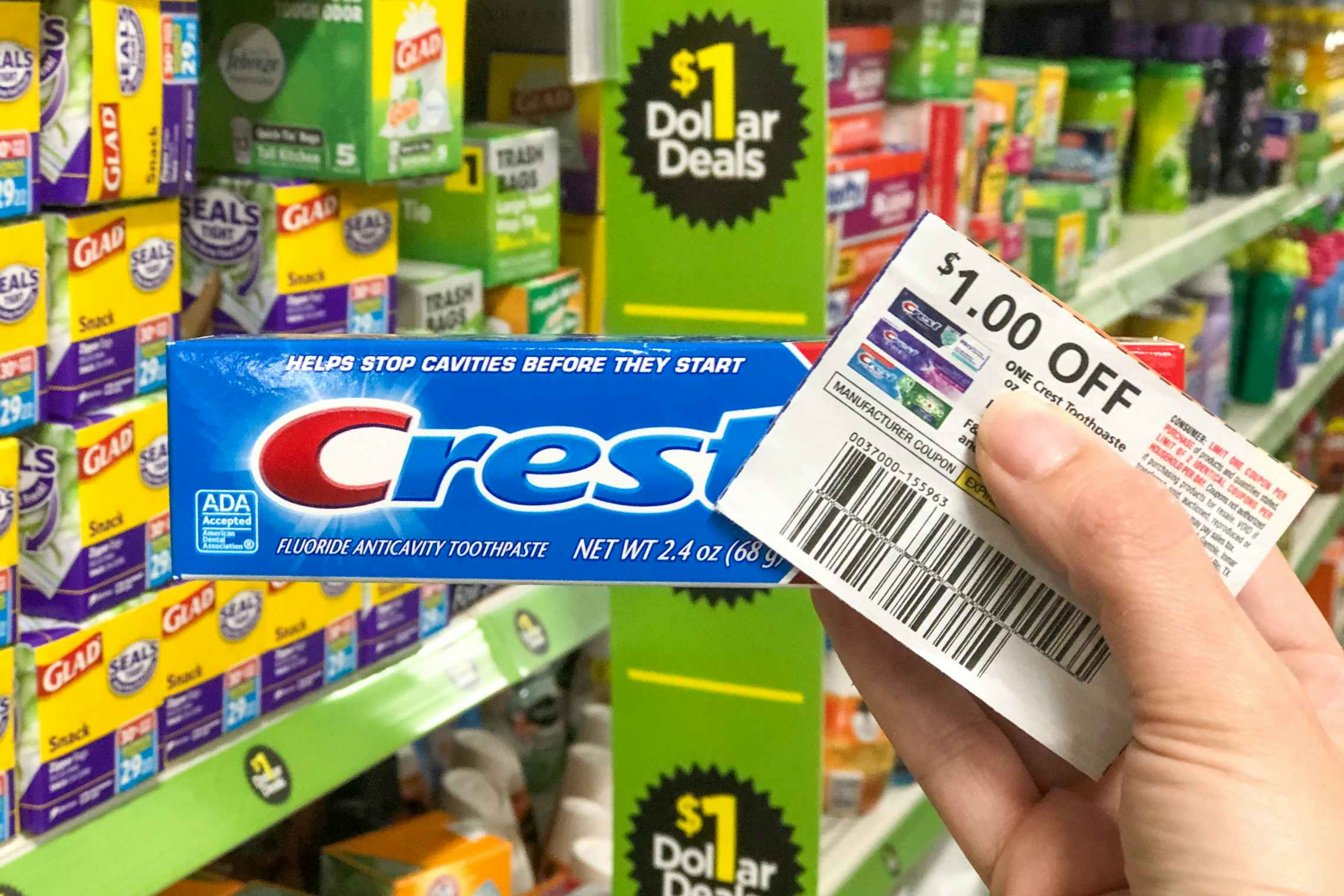 $1 off coupons next to a box of Crest toothpaste