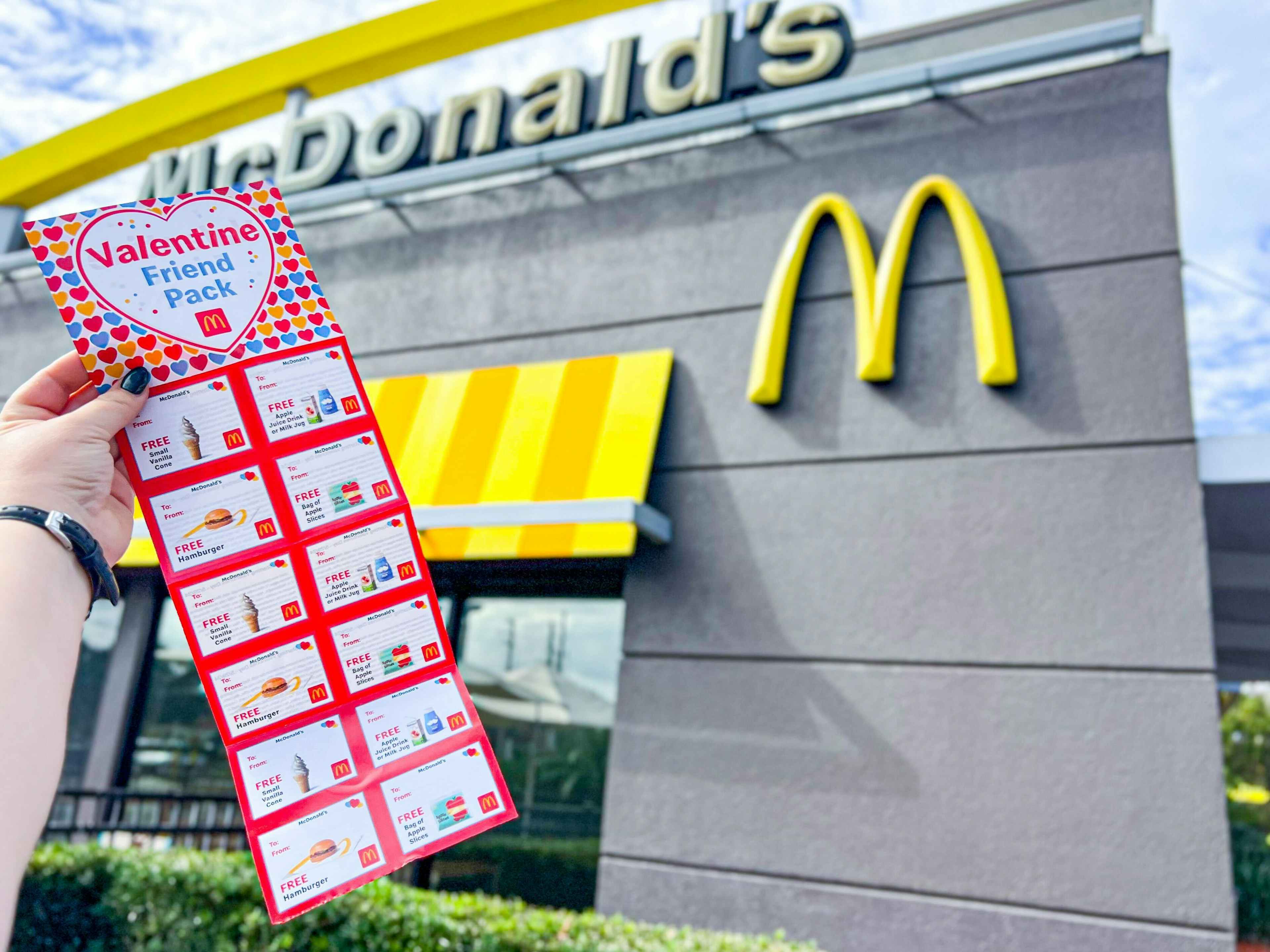 someone holding a mcdonalds valentine friend pack, showing the coupons