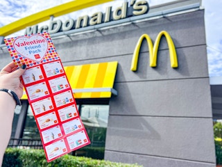 someone holding a mcdonalds valentine friend pack, showing the coupons