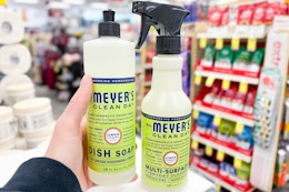 person holding mrs meyers dish soap by mrs meyers cleaning spray