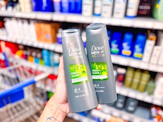hand holding two bottles of dove men care 2-in-1 shampoo in walmart aisle