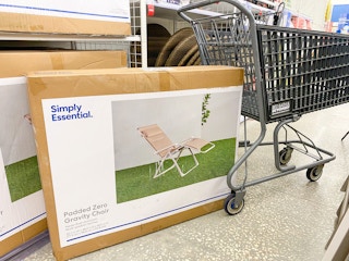 Padded zero or anti gravity chair on floor with cart in background