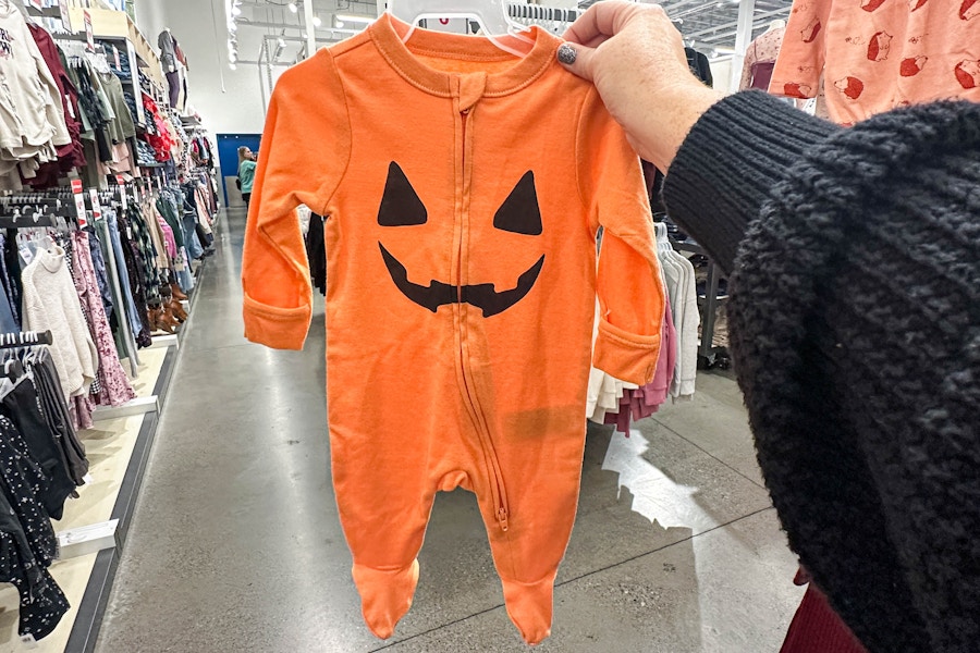 a halloween onesie being held 