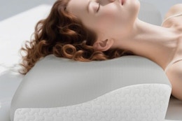 a woman using a cervical neck pillow