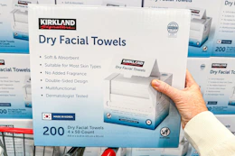 hand holding a box of kirkland signature facial towels