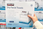 hand holding a box of kirkland signature facial towels