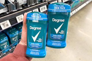 hand holding two packs of degree deodorant in walmart aisle