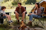 family sitting around camp fire