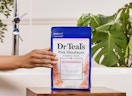 a hand holding a bag of epsom salt soak
