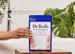 a hand holding a bag of epsom salt soak