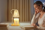 a woman using a candle warmer lamp