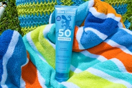 Blue lizard sensitive sunscreen on beach towel