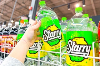 hand picking up a 2 liter bottle of starry soda