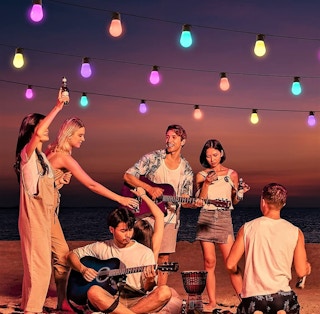 A group of people dancing outside under Govee string lights.