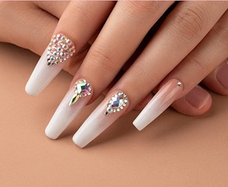 A hand with white and pink painted nails.