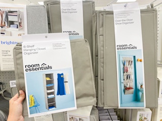 A hand holding a 6 shelf hanging closet organizer by Room Essentials