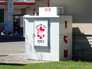 An ice machine located outside of a gas station