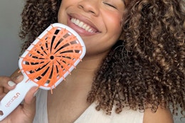 a woman holding the fhi unbrush plus