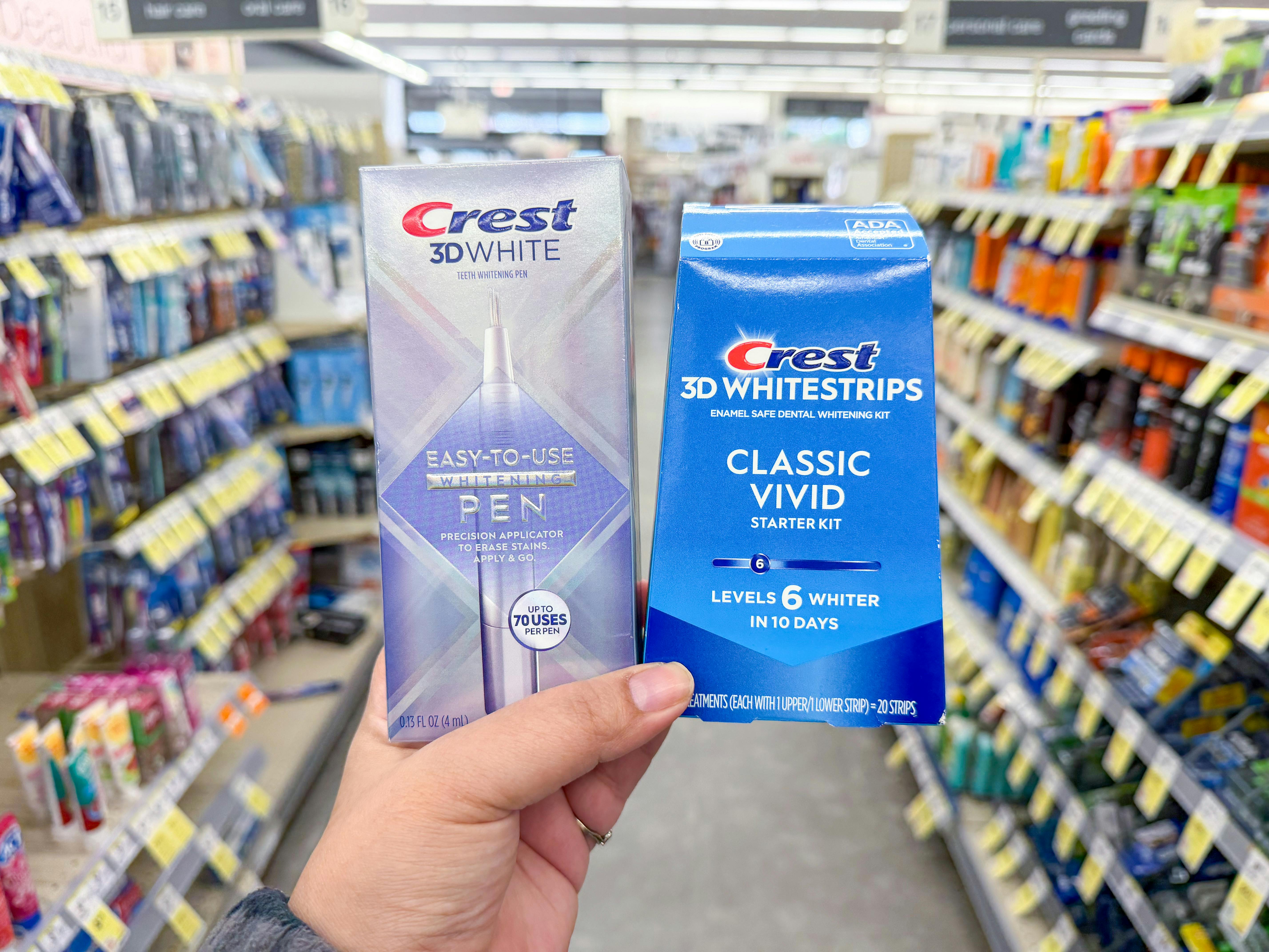 hand holding crest pen and whitening kit in walgreens