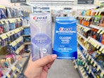 hand holding crest pen and whitening kit in walgreens
