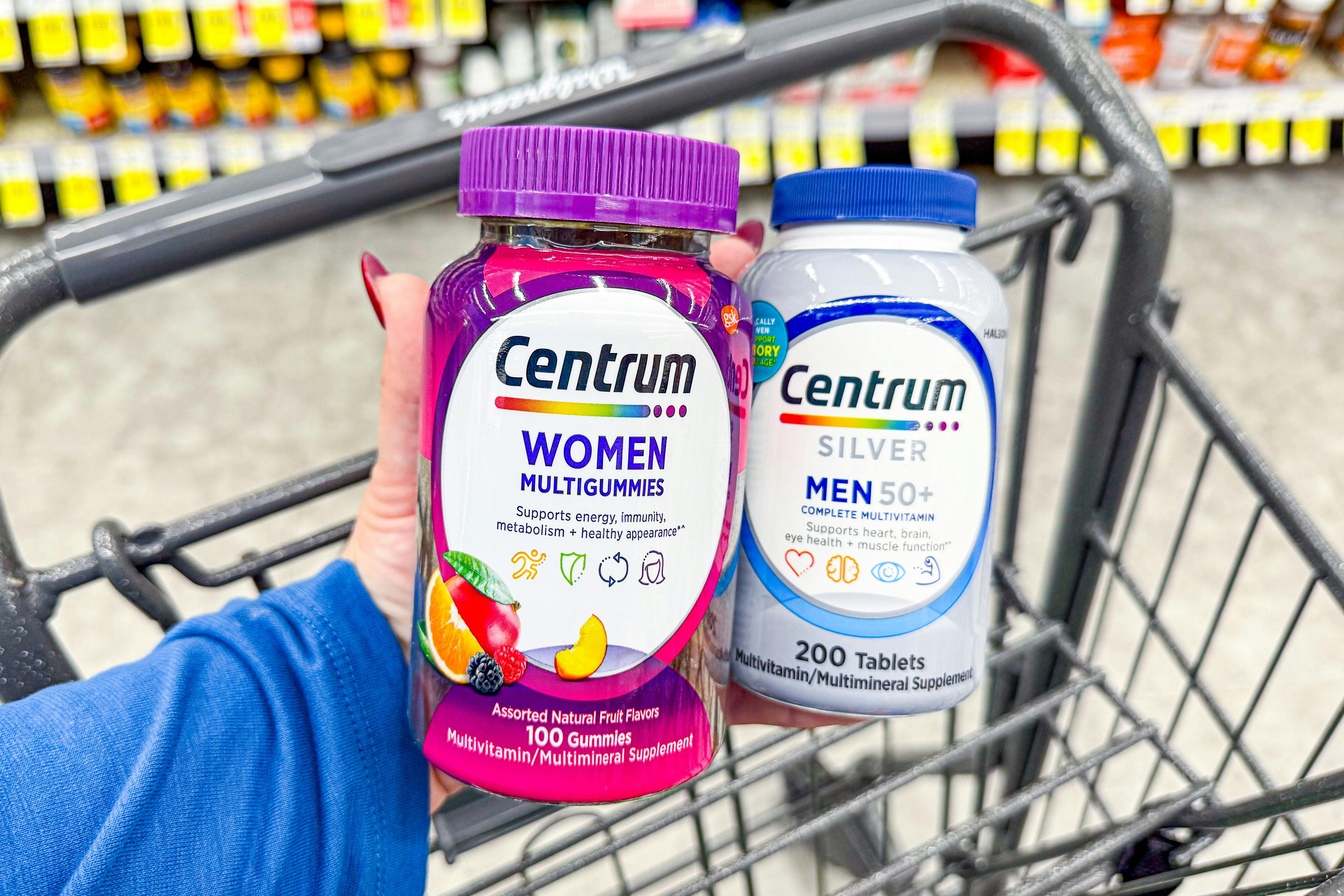 hand holding two bottles of centrum vitamins